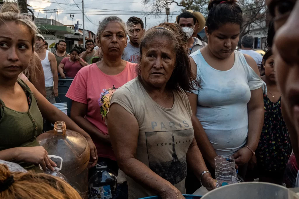 La gente a veces tiene que esperar horas en fila antes de poder llenar sus recipientes con agua que brinda el gobierno.